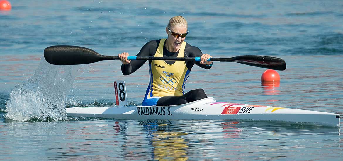 Kvinna som paddlar i en K1 kajak.